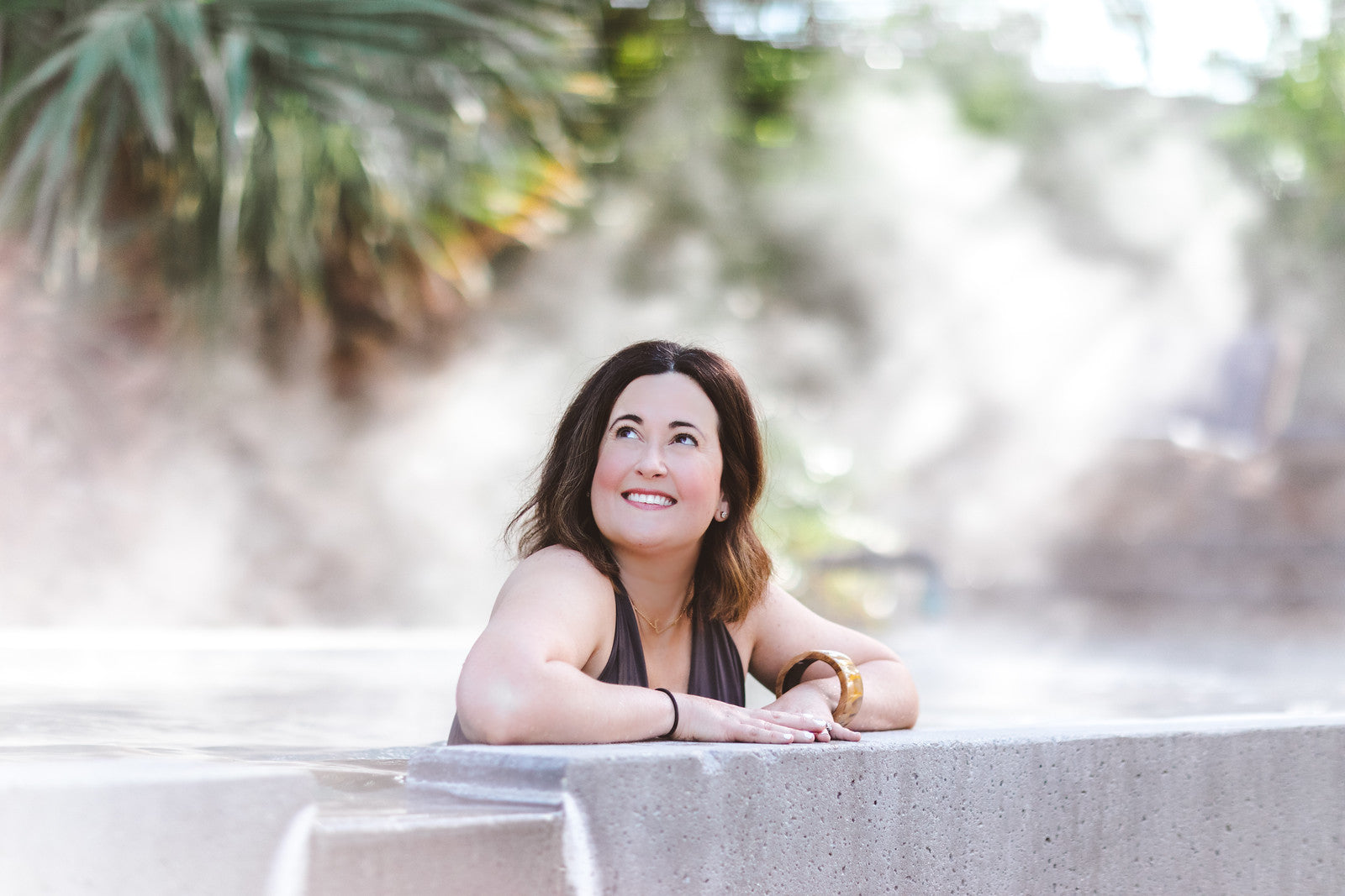 Jennie Fresa smiling and looking off camera relaxing in a pool